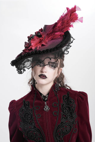 Gothic woman in a red velvet Victorian outfit wearing eva lady eas02402 a crimson feathered hat with black lace and roses, styled for Lady Dimitrescu-inspired cosplay on a white background.