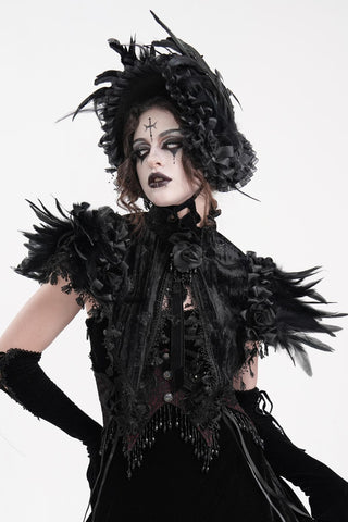 Model wearing a black feathered gothic capelet with lace trim, rose embellishments, high collar and dramatic feathered shoulders.
