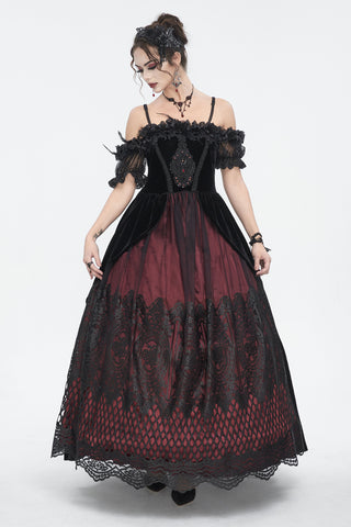 Woman wearing a black velvet and burgundy lace off-shoulder maxi dress.