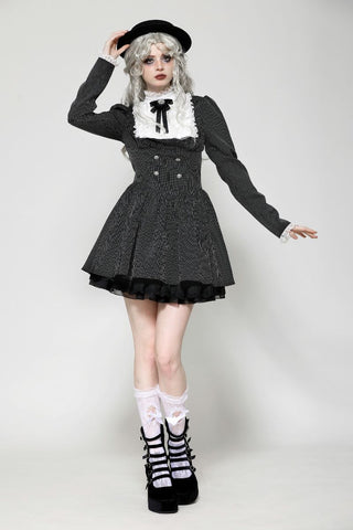 Full body view of model posing in black Gothic pinafore dress with white lace collar