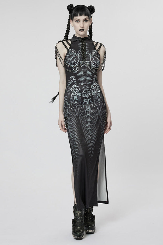 Model wearing a long black cyberpunk dress with silver alien-like print, lace-up chest, side slits, and shoulder chain straps