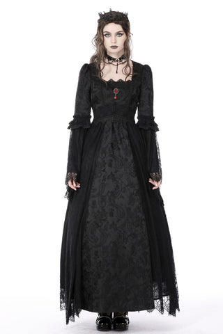 Model standing in full view wearing black Gothic dress with red pendant and lace detail