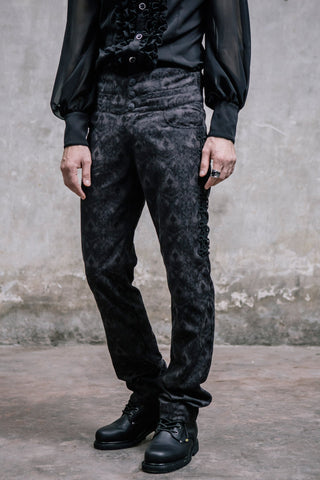 Side angle view of men’s Gothic brocade trousers worn with black ruffled shirt and boots, showing lace-up side detailing and slim fit.