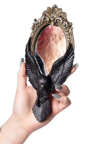 Gothic raven hand mirror with black wings and antique gold frame held in one hand
