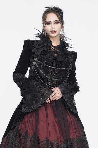 Model wearing a black velvet Gothic bolero jacket with lace, feathers, and silver chains, paired with a burgundy Victorian skirt