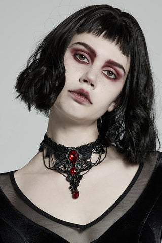 Model wearing a Gothic Victorian black lace choker with red gemstones and chain details