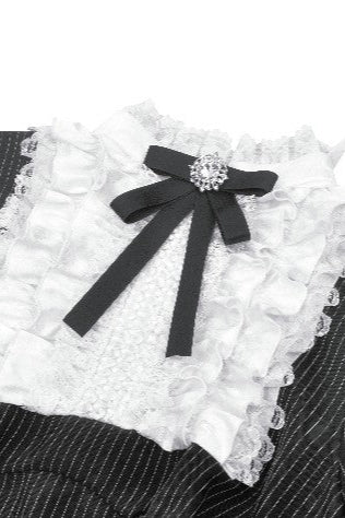 Close-up of white ruffled lace collar and black ribbon bow for pinafore dress