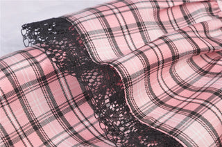 Close-up of black lace trim on pink plaid Gothic mini skirt