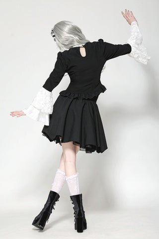 Back view of model in black and white Lolita blouse with flared lace sleeves