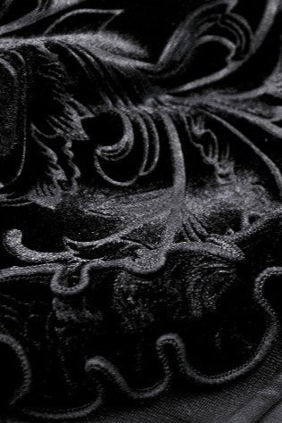 Detailed close-up of Mooncaller shrug showing embossed velvet pattern and ruffled trim