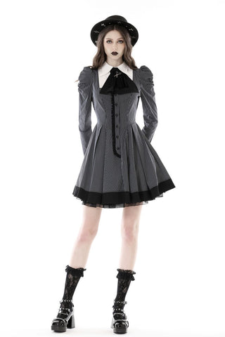 posing in short Gothic pinafore dress with boots