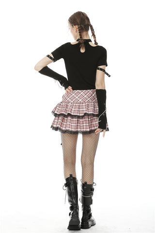 Back view of pink plaid mini skirt worn by model with black top and boots