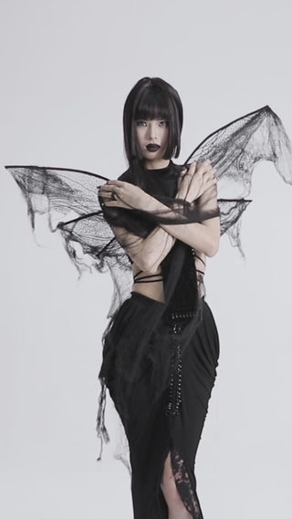 Model wearing Punk Rave tattered black mesh moth wings, turning to show wired frame, elastic straps, and subtle sequins on a white studio background.