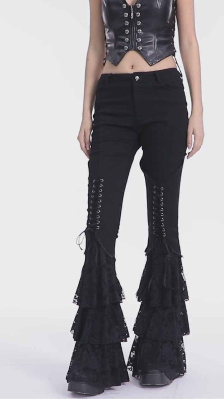 Model showing Punk Rave WK-657 black Gothic flared pants with lace-up front and tiered lace ruffle hems.