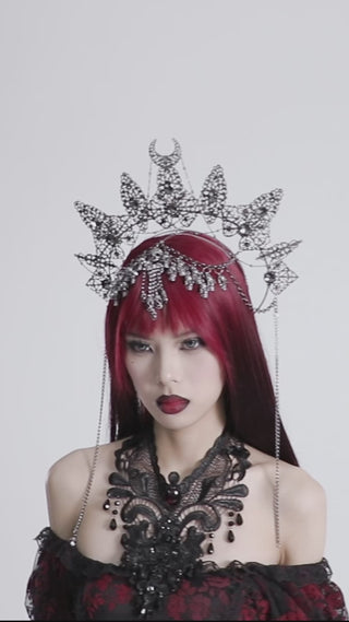 Video showing a model wearing the Punk Rave WS-737 Gothic halo crown with silver skulls, spiked arcs, and chain details, paired with a red and black lace dress
