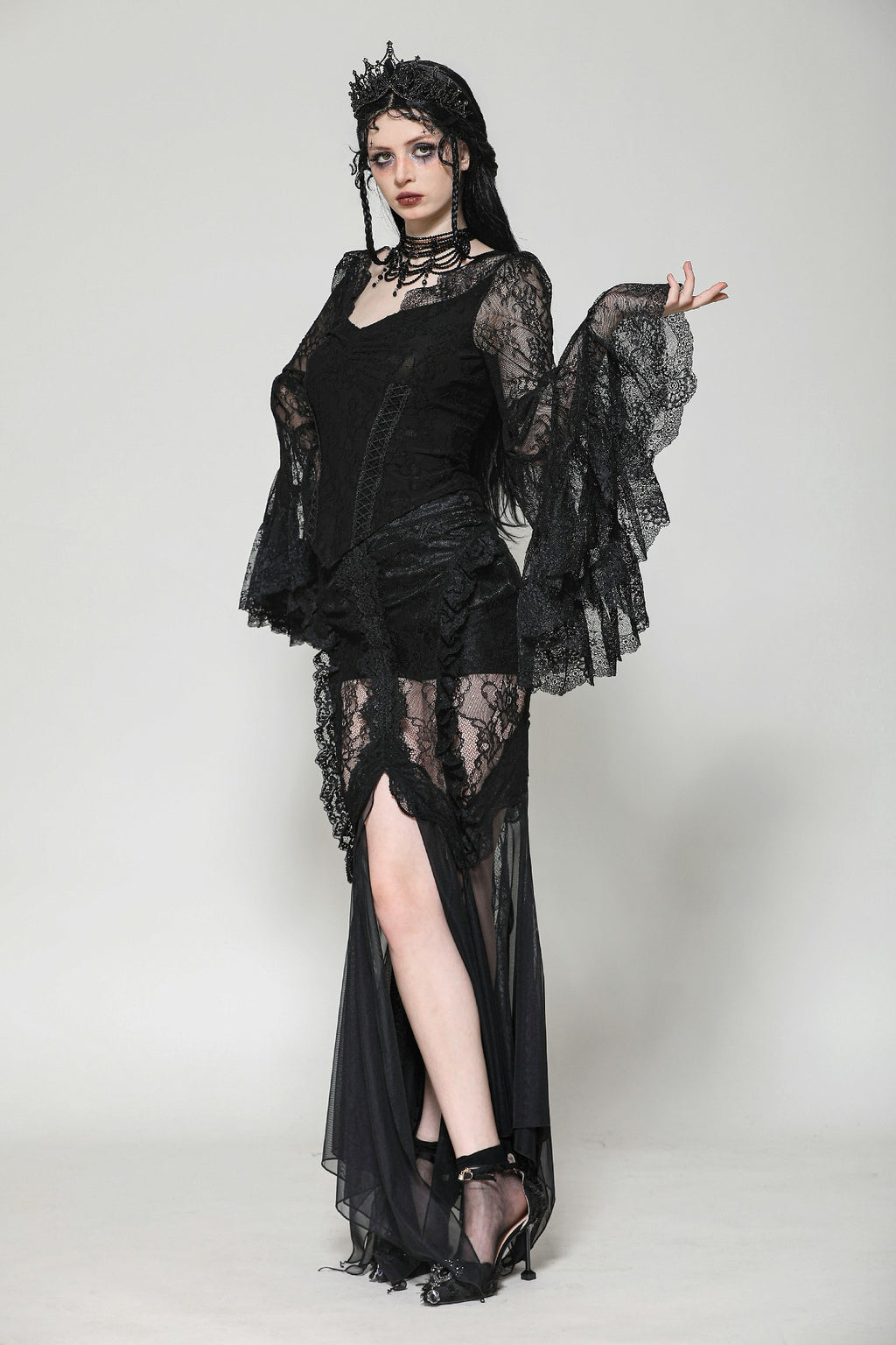 Model showcasing Dark in Love TW607 Gothic black lace top with sheer bell sleeves and basque hem, turning to display front and side details.