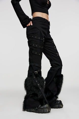 Side view of model wearing black flared Punk Rave wk-526 pants with faux fur trim, mesh panels, and strap details, styled with platform boots on a white background.