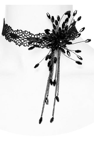 Close-up of black lace choker with a beaded 3D flower motif and long chain tassels, shown on a white mannequin neck against a white background.