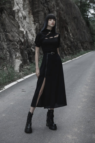 Woman wearing a black Gothic A-line maxi skirt with adjustable zip slit and platform boots