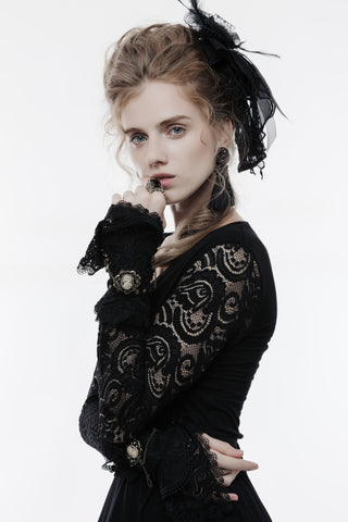 Woman in a black lace Victorian-inspired outfit wearing ornate black lace wrist cuffs with cameo accents, posing against a white background.