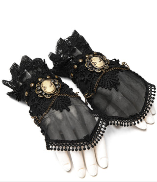 Punk Rave black lace wrist cuffs with ruffled trim, antique gold chains, and ornate cameo centerpieces, displayed on mannequin hands against a white background