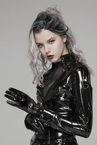 Woman in a black latex outfit and black faux leather gloves with mesh panels and spike studs, posing against a neutral background.