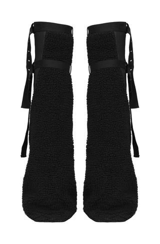 Back view of black flared sherpa legwarmers with buckle straps on a white background.
