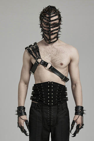 Male model wearing Punk Rave WS-636 black faux leather one-shoulder harness with multi-strap buckle detail and O-ring hardware, styled shirtless with spiked mask and Gothic accessories.