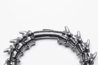 Close-up of silver vertebrae-style hinged bracelet clasp on white background