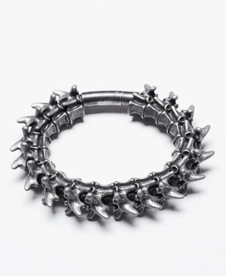 Silver vertebrae-style hinged bracelet with 3D spine bone design on white background