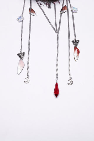 Close-up of Punk Rave Gothic red jeweled crown chains with silver crescent moons, butterfly charms, crystal drops, and red gemstone pendant details.