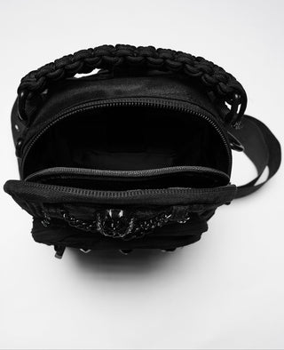 Interior storage compartment of black utility sling bag with zip opening and layered pocket layout