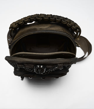 Interior storage compartment of brown distressed utility sling bag with zip opening and layered pockets