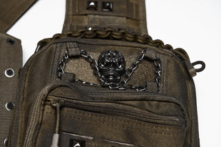 Close-up of black skull hardware and chain detail on brown distressed utility sling bag