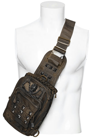 Brown distressed utility sling bag with skull chain detail and adjustable crossbody strap on white mannequin display