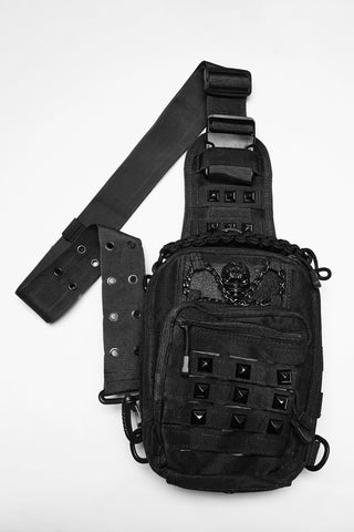 Black utility sling bag with skull chain detail, studded front pocket and adjustable crossbody strap on white background