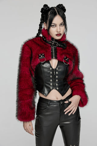 Model wearing a cropped red faux fur bolero jacket with black PVC straps and high collar, styled over a black corset and leather pants on a neutral gray background.