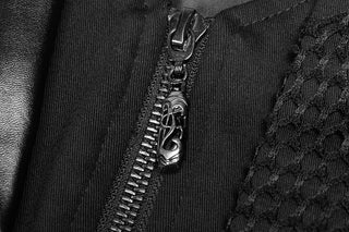 Close-up of black zipper with ornate metal pull tab on a coat featuring leather, twill, and fishnet textures.