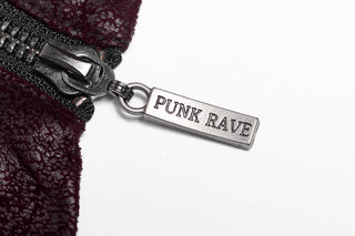 Macro shot of a metallic zipper pull engraved with “PUNK RAVE” against maroon textured faux leather and white background.