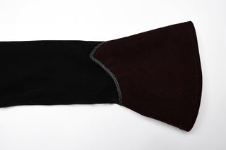 Close-up of black sleeve with burgundy velvet flared cuff and decorative trim