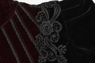 Close-up of black floral embroidery over burgundy velvet panel on Gothic jacket