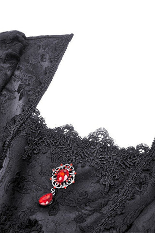Red pendant brooch on black lace bodice with floral trim detail