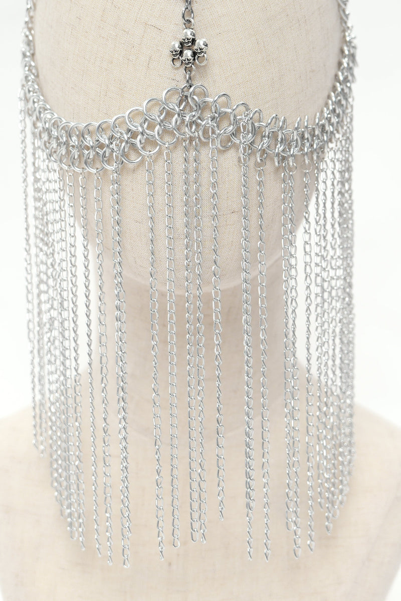 Close-up of silver chain face veil on mannequin showing layered metal drape and looped forehead design