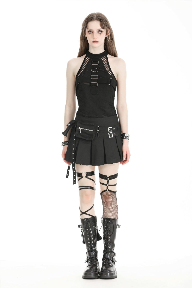 Front view of model wearing a black techwear mini skirt with pleats, two utility pockets, belt buckles, and strappy combat boots