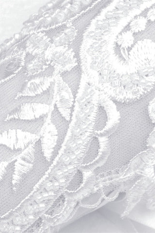 Macro close-up of floral embroidery and beaded lace detail on white mesh glove