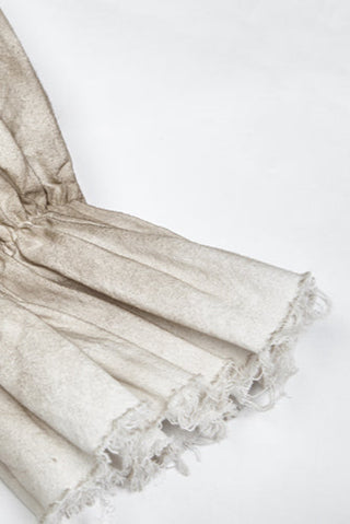 Close-up of gathered cuff with frayed edge on distressed white pirate shirt